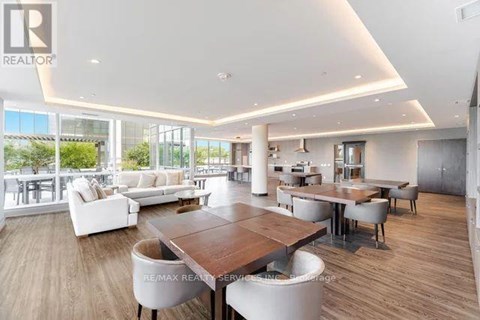 A spacious living room with a large wooden table and white chairs.