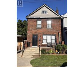A brick house with a black front door and a small porch.