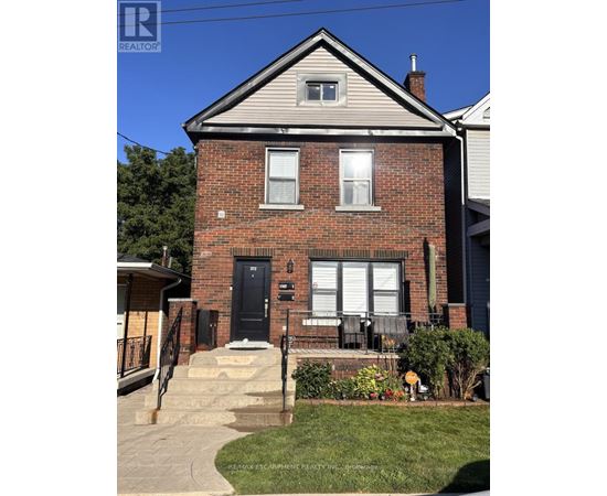 A brick house with a black front door and a small porch.