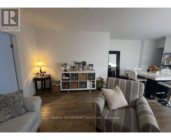 A living room with a grey couch and a wooden floor.
