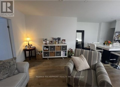 A living room with a grey couch and a wooden floor.