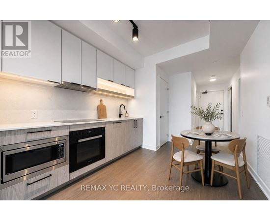 A modern kitchen with white cabinets and stainless steel appliances.