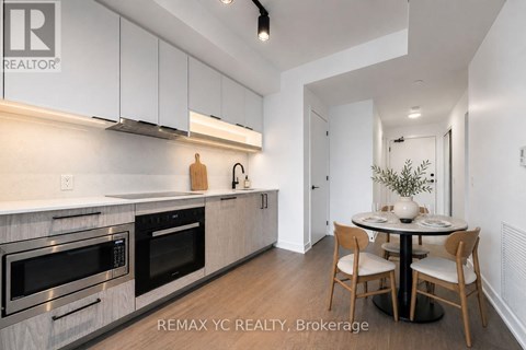 A modern kitchen with white cabinets and stainless steel appliances.