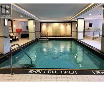 A swimming pool with a shallow area sign on the floor.