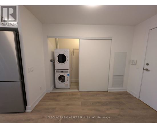 A small room with a washer and dryer stacked on top of each other.