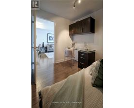 A bedroom with a bed, desk, and chair.