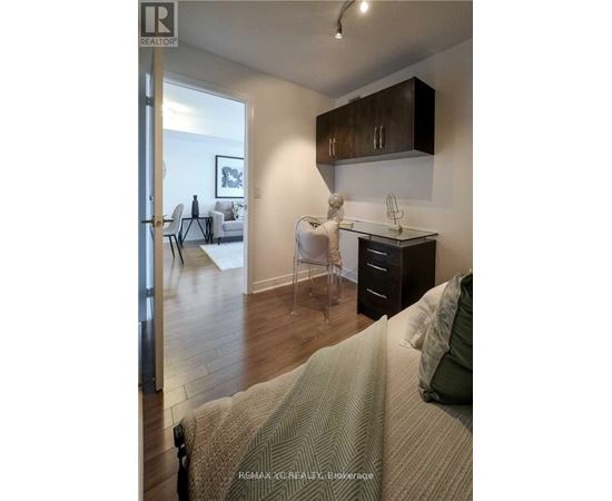 A bedroom with a bed, desk, and chair.