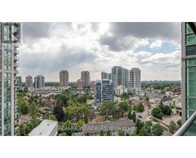 A cityscape with tall buildings and a cloudy sky.