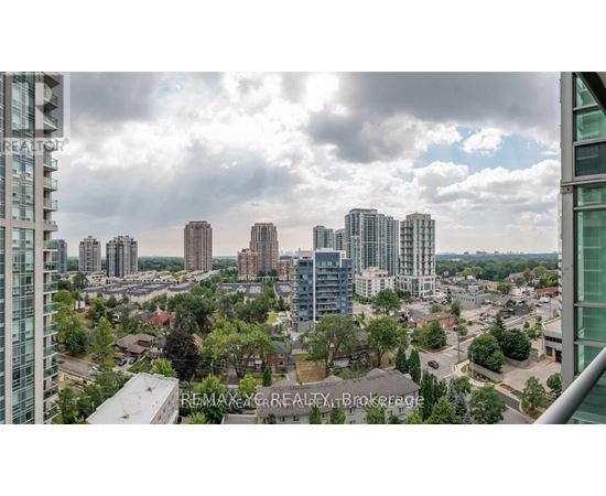 A cityscape with tall buildings and a cloudy sky.