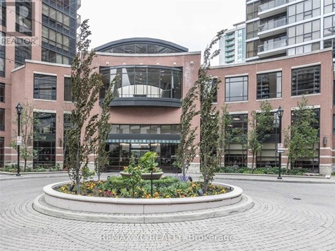 A large building with a circular flower bed in front of it.