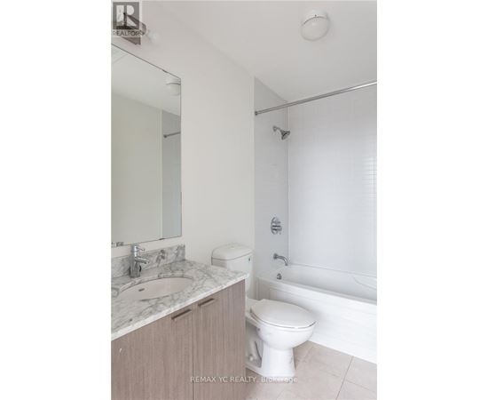 A white toilet sits next to a sink in a bathroom.