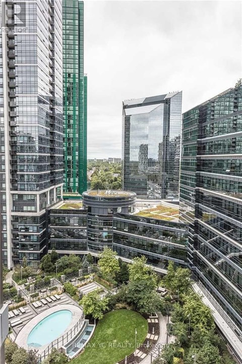 A modern building complex with a pool and greenery.