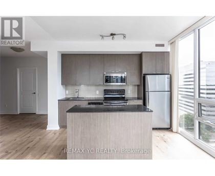 A modern kitchen with a wooden island and stainless steel appliances.