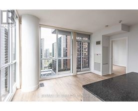 A room with a view of the city through large windows.