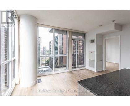 A room with a view of the city through large windows.