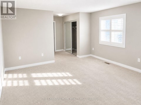 A room with a carpeted floor and a window with blinds.