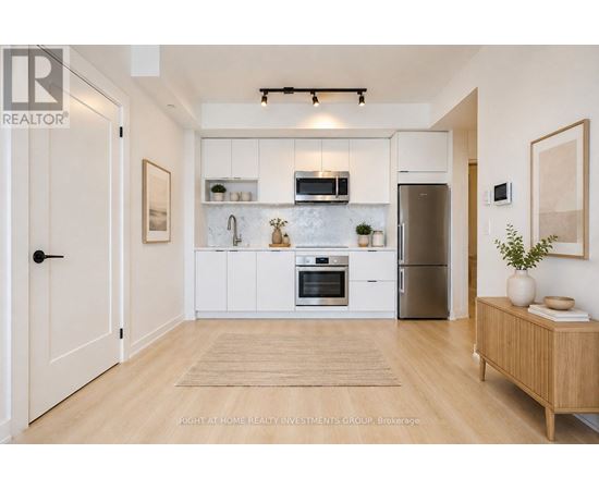 A kitchen with white cabinets and a refrigerator.