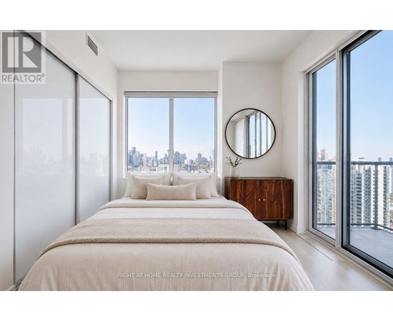 A bedroom with a large bed and a view of the city.