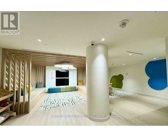A living room with a white column in the middle and a blue chair on the right.