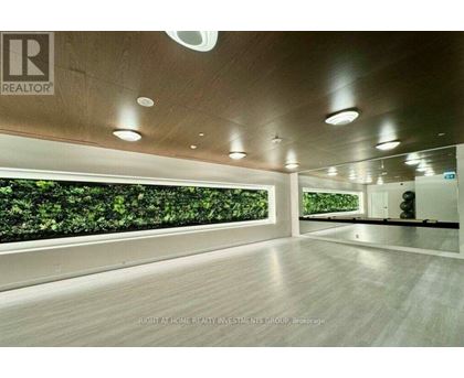 A spacious room with a green wall and wooden flooring.