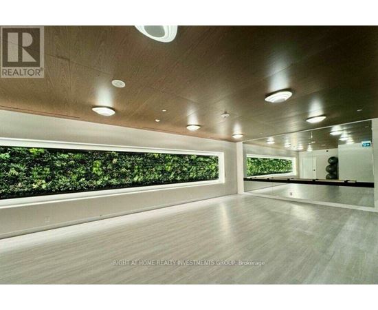 A spacious room with a green wall and wooden flooring.