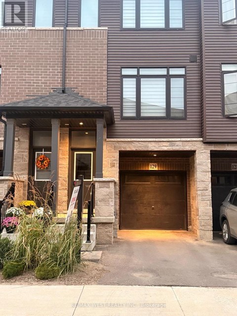 A brown building with a garage door numbered 129.