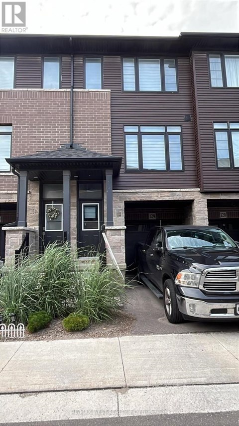 A black truck is parked in front of a brown building.