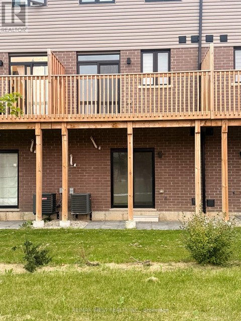 A house with a balcony and a green lawn in front.