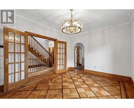 A large open space with a wooden floor and a chandelier hanging from the ceiling.