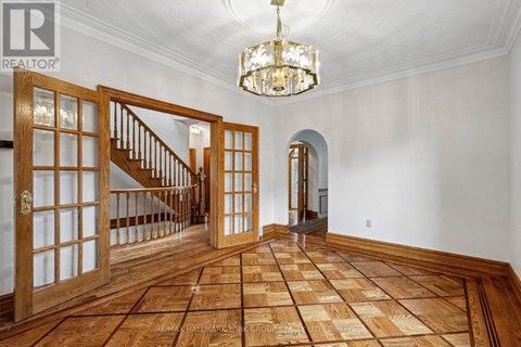 A large open space with a wooden floor and a chandelier hanging from the ceiling.