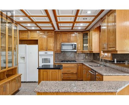 A kitchen with wooden cabinets and a white refrigerator.
