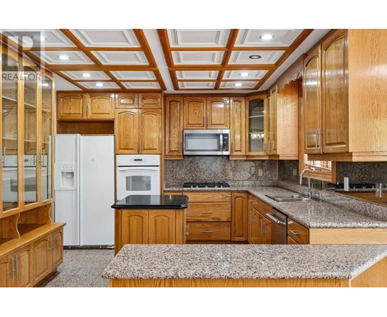 A kitchen with wooden cabinets and a white refrigerator.
