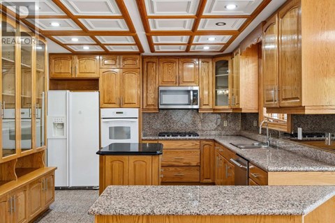 A kitchen with wooden cabinets and a white refrigerator.