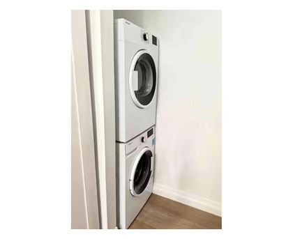A white front loading washing machine in a room.