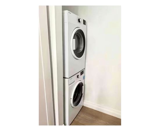 A white front loading washing machine in a room.