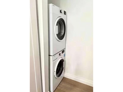A white front loading washing machine in a room.