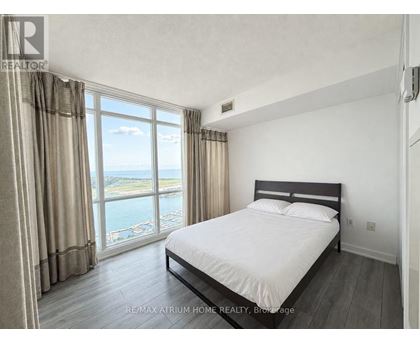 A bedroom with a large bed and a view of the water.
