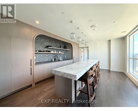 A kitchen with a marble countertop and wooden floors.