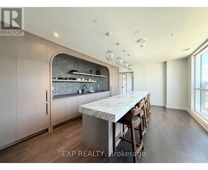 A kitchen with a marble countertop and wooden floors.