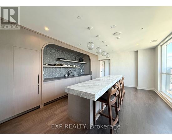 A kitchen with a marble countertop and wooden floors.