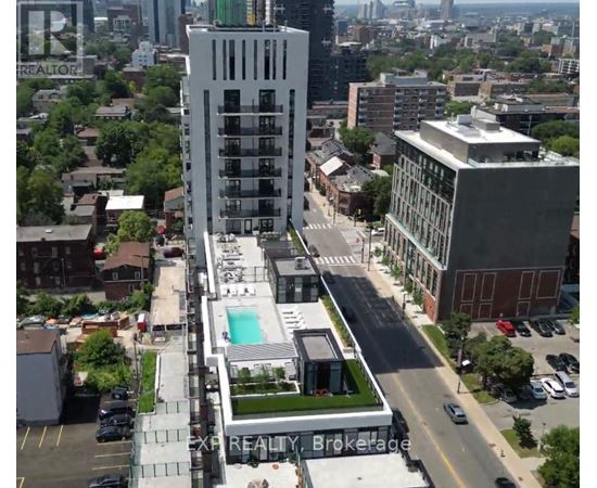 A tall building with a pool in the middle of a parking lot.