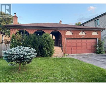 A red brick house with a garage door numbered 191.