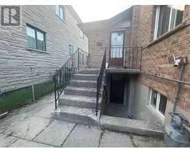 A staircase with a metal railing leads to a doorway in a building.