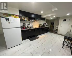 A kitchen with a white fridge and black cabinets.