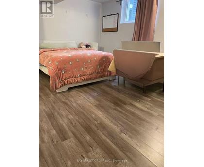 A bedroom with a bed and a chair.