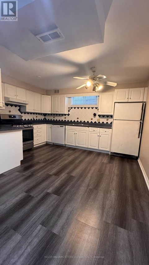 A kitchen with white cabinets and a black stove top oven.