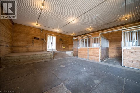 A spacious room with wooden walls and a concrete floor.