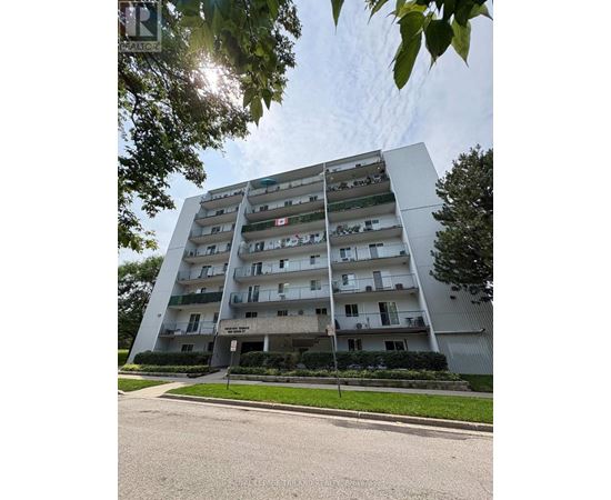 A tall apartment building with balconies on the upper floors.