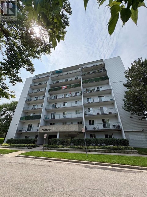 A tall apartment building with balconies on the upper floors.