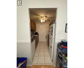 A kitchen with a white fridge and a white ceiling fan.
